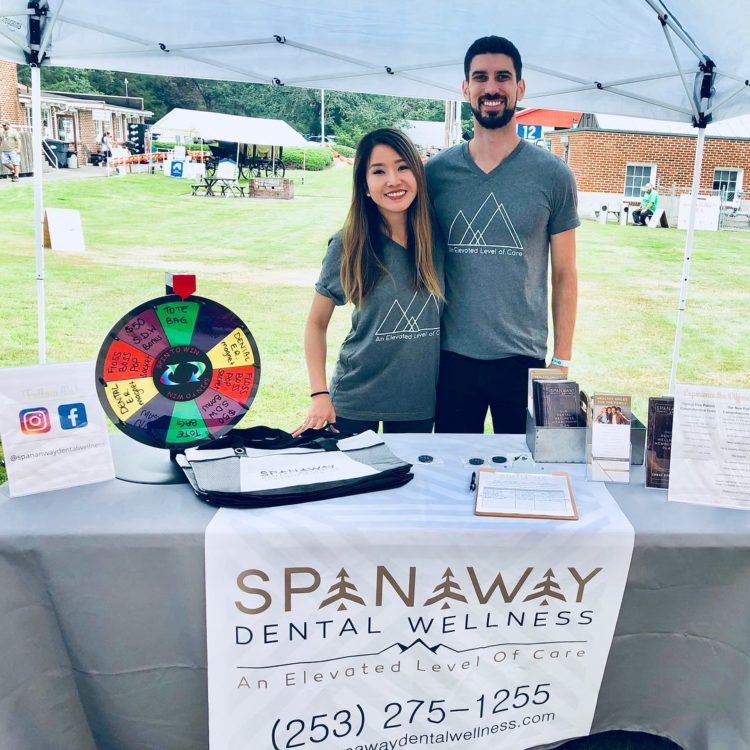 Dr. Perlman and Dr. Mai stand at their Elevate Smile Design vendor booth at the LeMay Car Show at Marymount