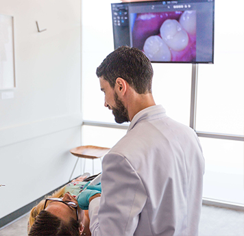 dentist examining inside of patient's mouth with intraoral camera