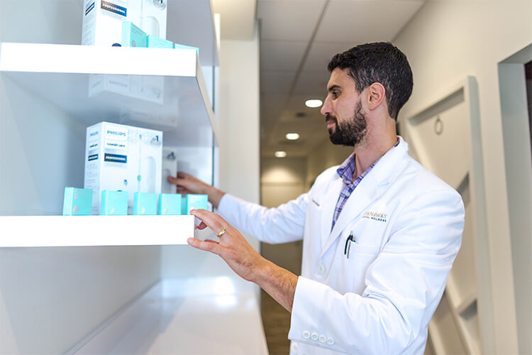 Dr Perlman placing an electronic tootbrush and floss on a shelf