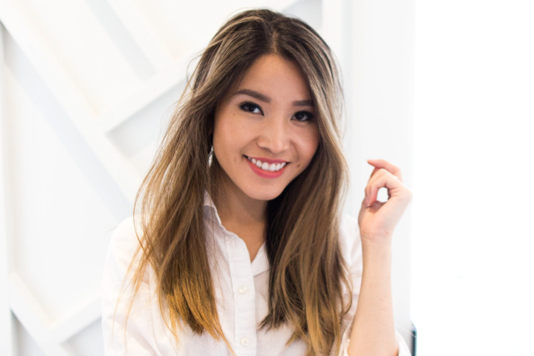 Dr. Mai wears a white blouse while smiling at Elevate Smile Design