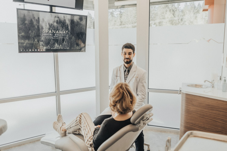 Dr. Perlman discusses with a blonde patient how to protect her oral health and overall health from the effects of gum disease