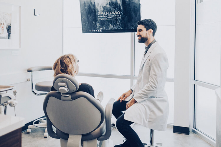 Woman talking to Dr. Perlman while in dentist chair