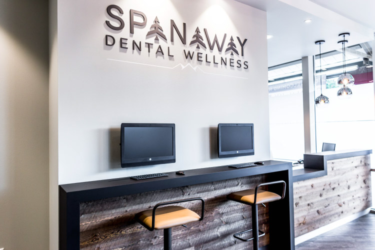 View of the Elevate Smile Design check-in station with computers, barstools, and modern design