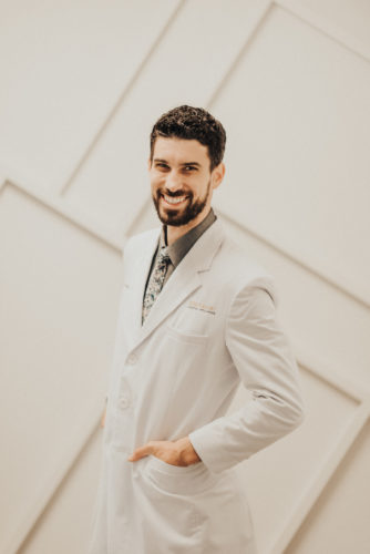 Dr. Perlman smiles while wearing a white dental coat at Elevate Smile Design