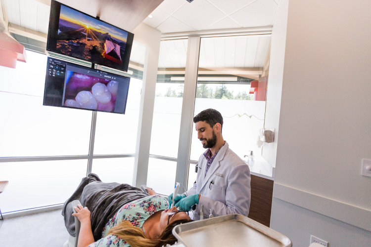 Dr. Perlman examines the teeth of a patient at Elevate Smile Design