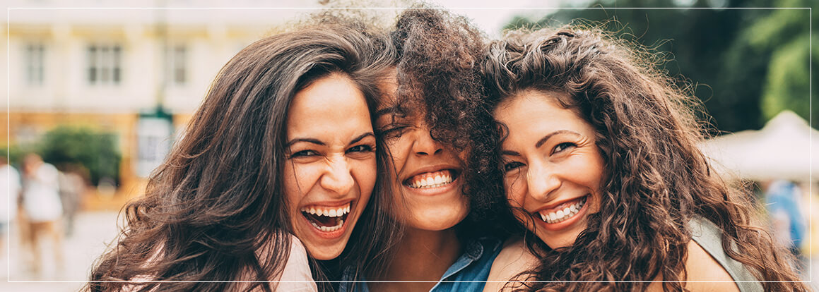 three female friends smiling together