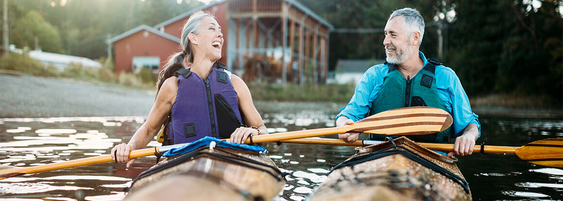 man and woman in kayaks laughing