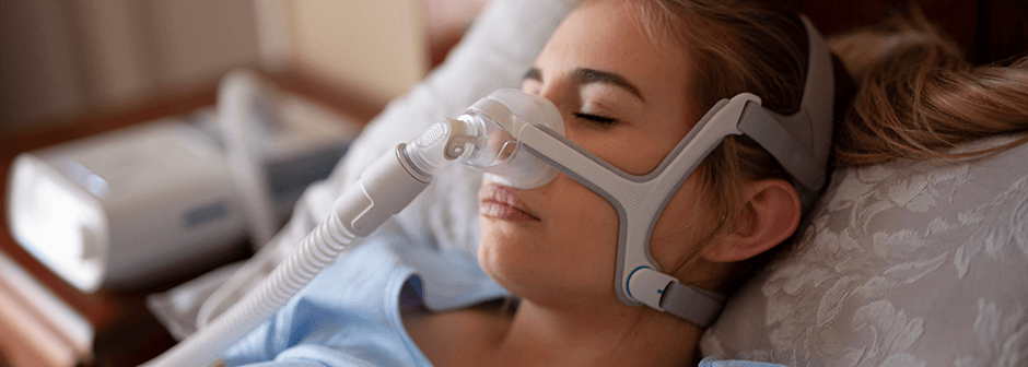 sleeping woman wearing a sleep apnea device