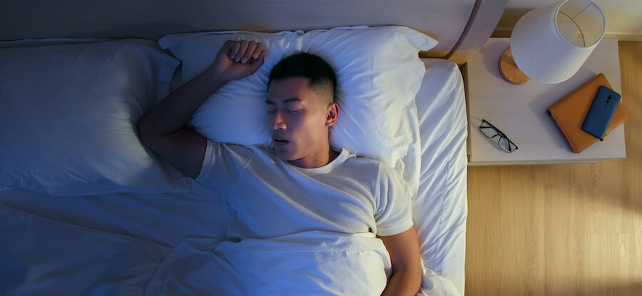 Aerial view of a man snoring as he sleeps in his bed